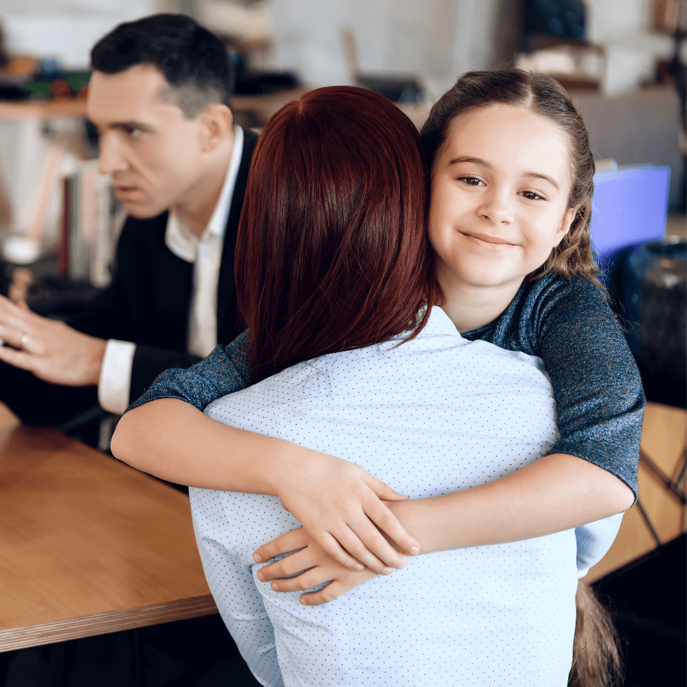 Jeune enfant souriant dans les bras de sa mère, de dos